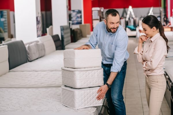 couple with folding mattresses in furniture store with arranged mattresses couple with folding mattresses in furniture store with arranged mattresses